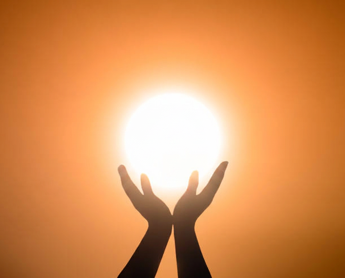 Open hands raised toward warm golden light
